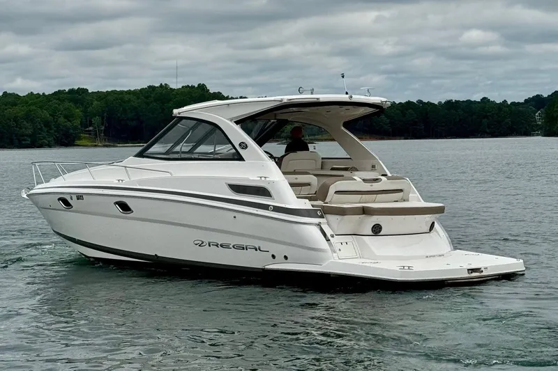  Yacht Photos Pics 2018 Regal 35 Sport Coupe boat cruising on a lake under cloudy skies.