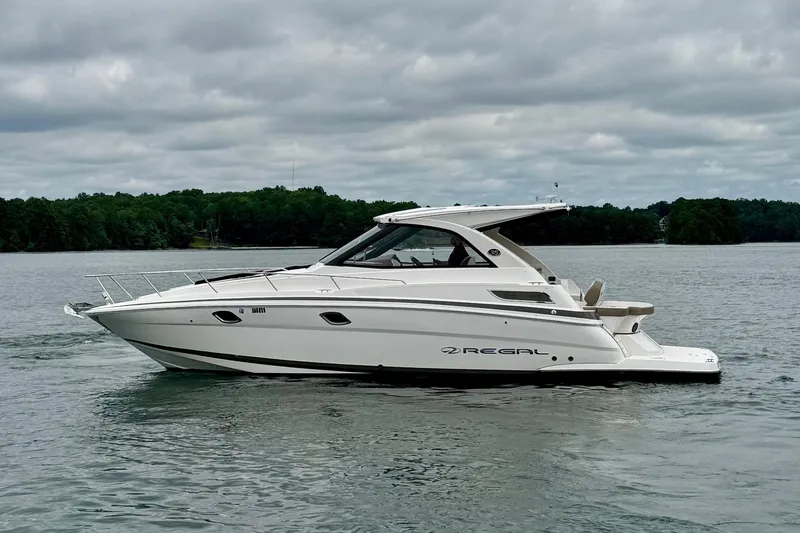  Yacht Photos Pics 2018 Regal 35 Sport Coupe boat on a calm lake under cloudy skies.