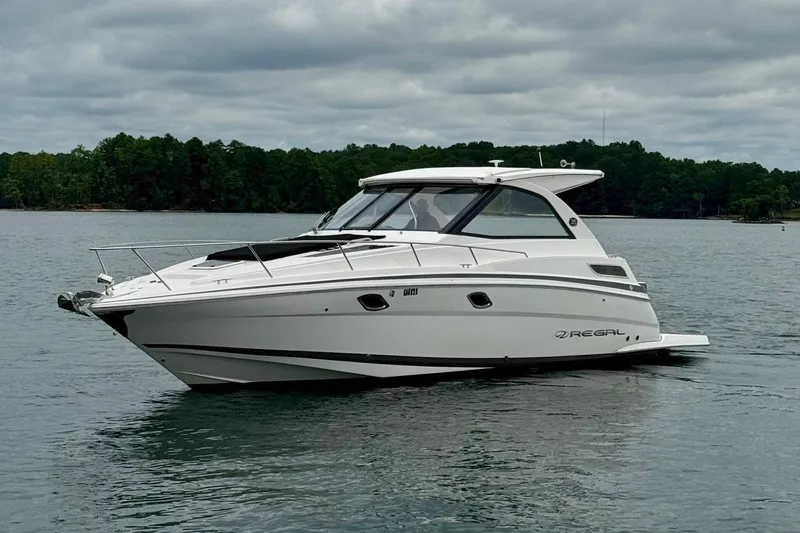 Yacht Photos Pics 2018 Regal 35 Sport Coupe boat on a calm lake under cloudy skies.