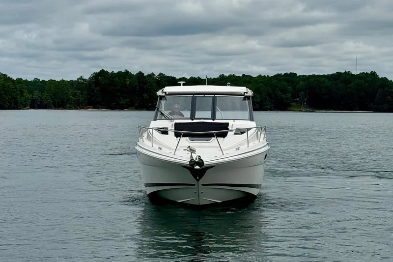  Yacht Photos Pics 2018 Regal 35 Sport Coupe cruising on a serene lake under cloudy skies.