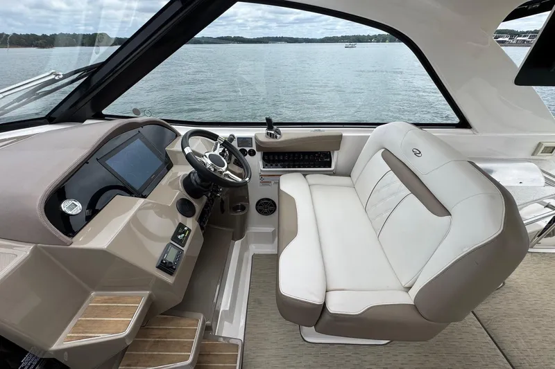  Yacht Photos Pics 2018 Regal 35 Sport Coupe helm with luxurious seating and modern controls, overlooking serene waters.