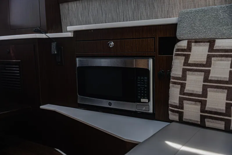  Yacht Photos Pics Modern kitchen area in 2021 Pursuit 428 boat with microwave and patterned seating.
