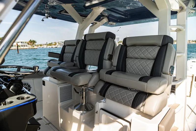  Yacht Photos Pics Luxurious seating on a 2021 Pursuit 428 boat with quilted upholstery, overlooking the water.