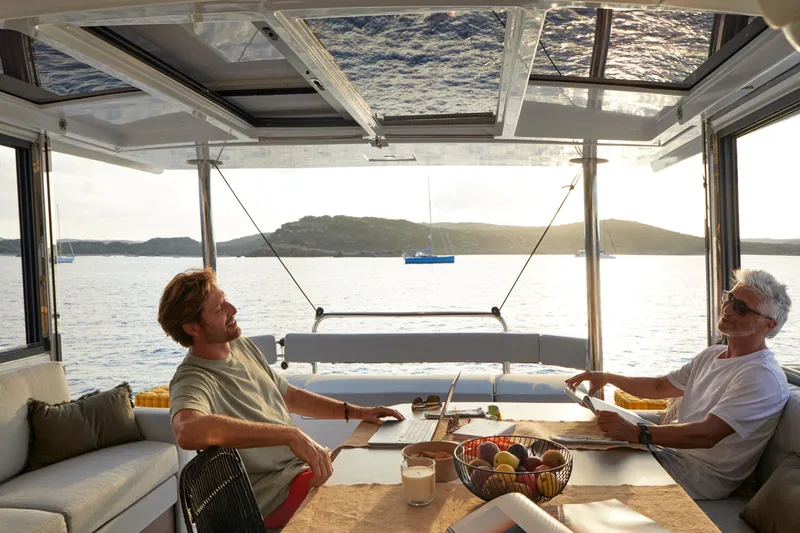 Roxy Yacht Photos Pics Two people relaxing on a Bali 4.4 catamaran, enjoying a scenic ocean view.