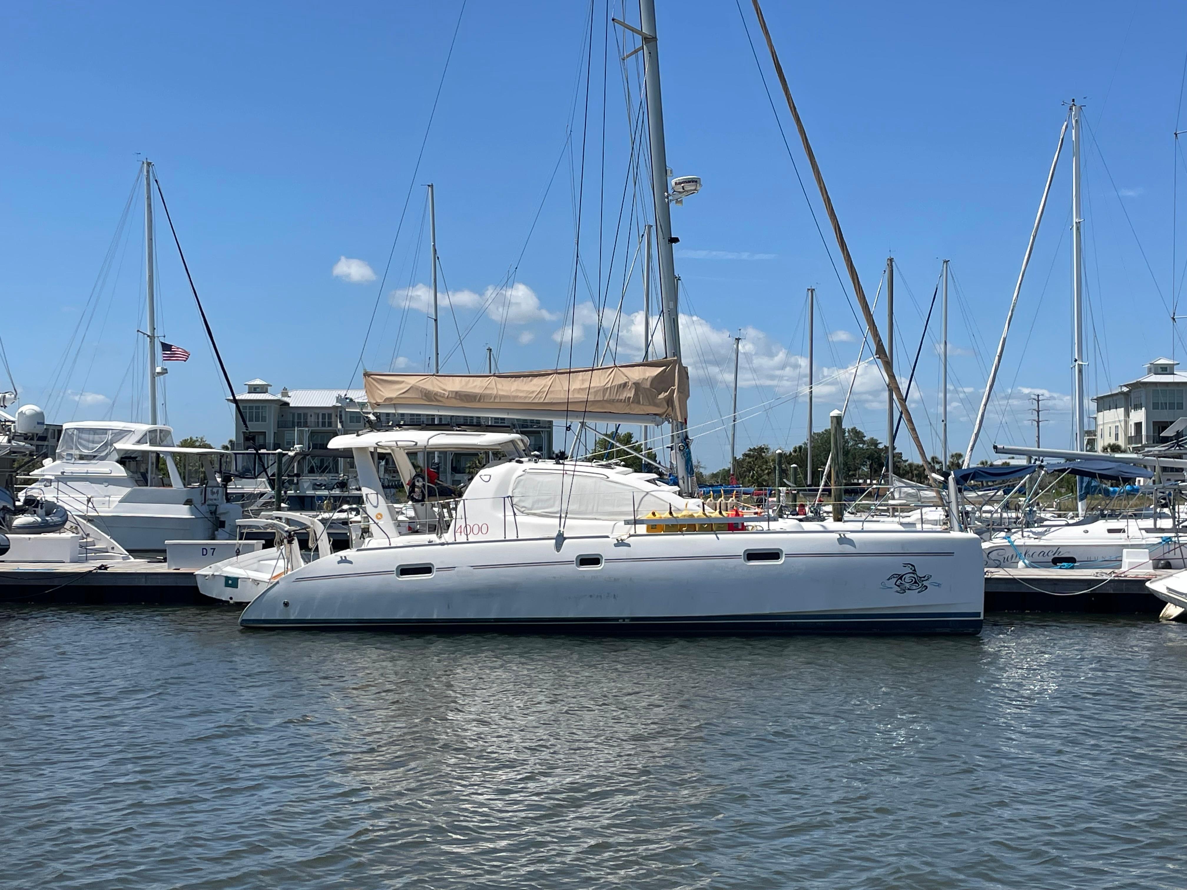 2005 Leopard 40 catamaran docked at marina under clear blue sky.