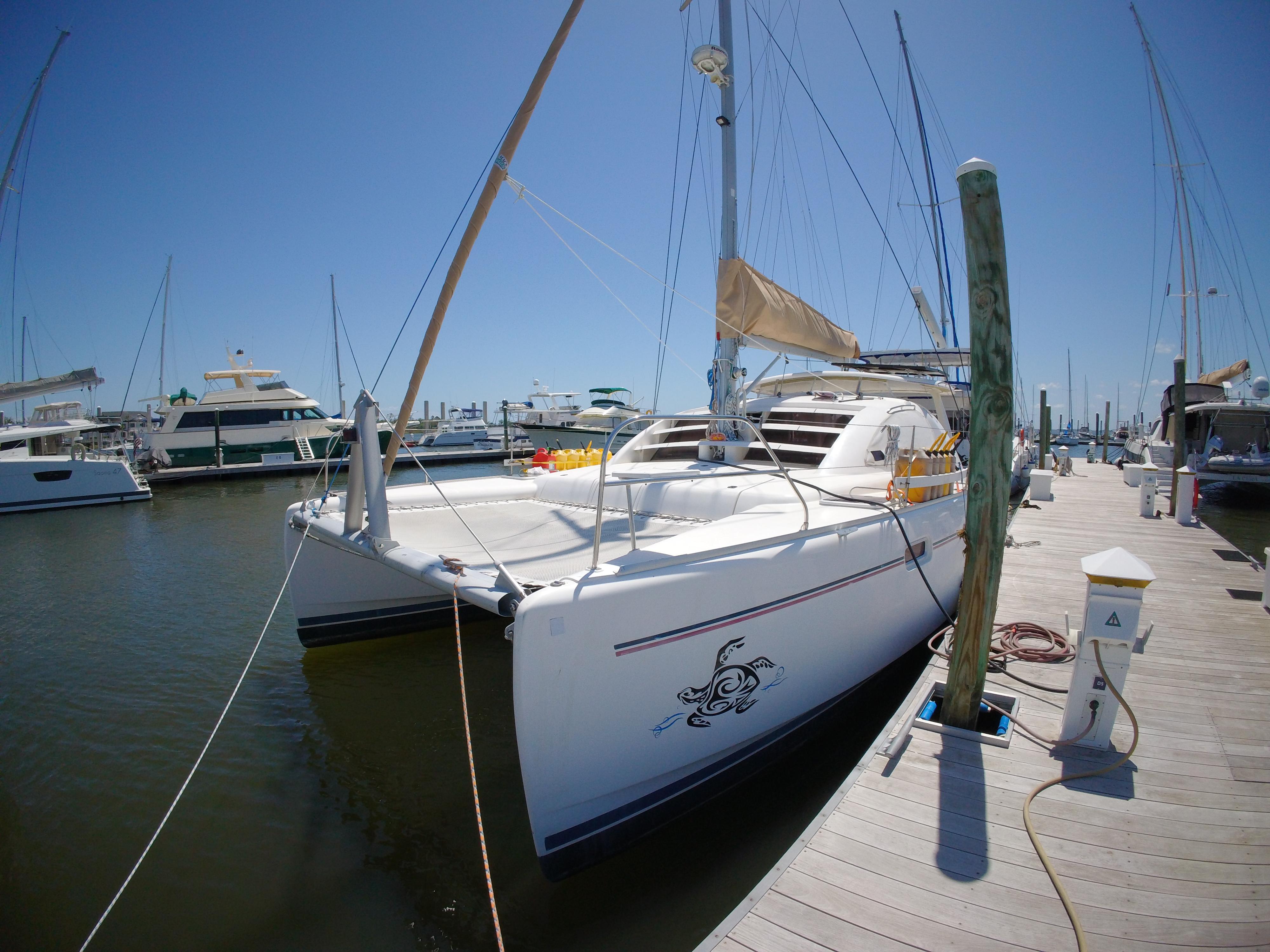 2005 Leopard 40 catamaran docked at marina under clear blue sky.
