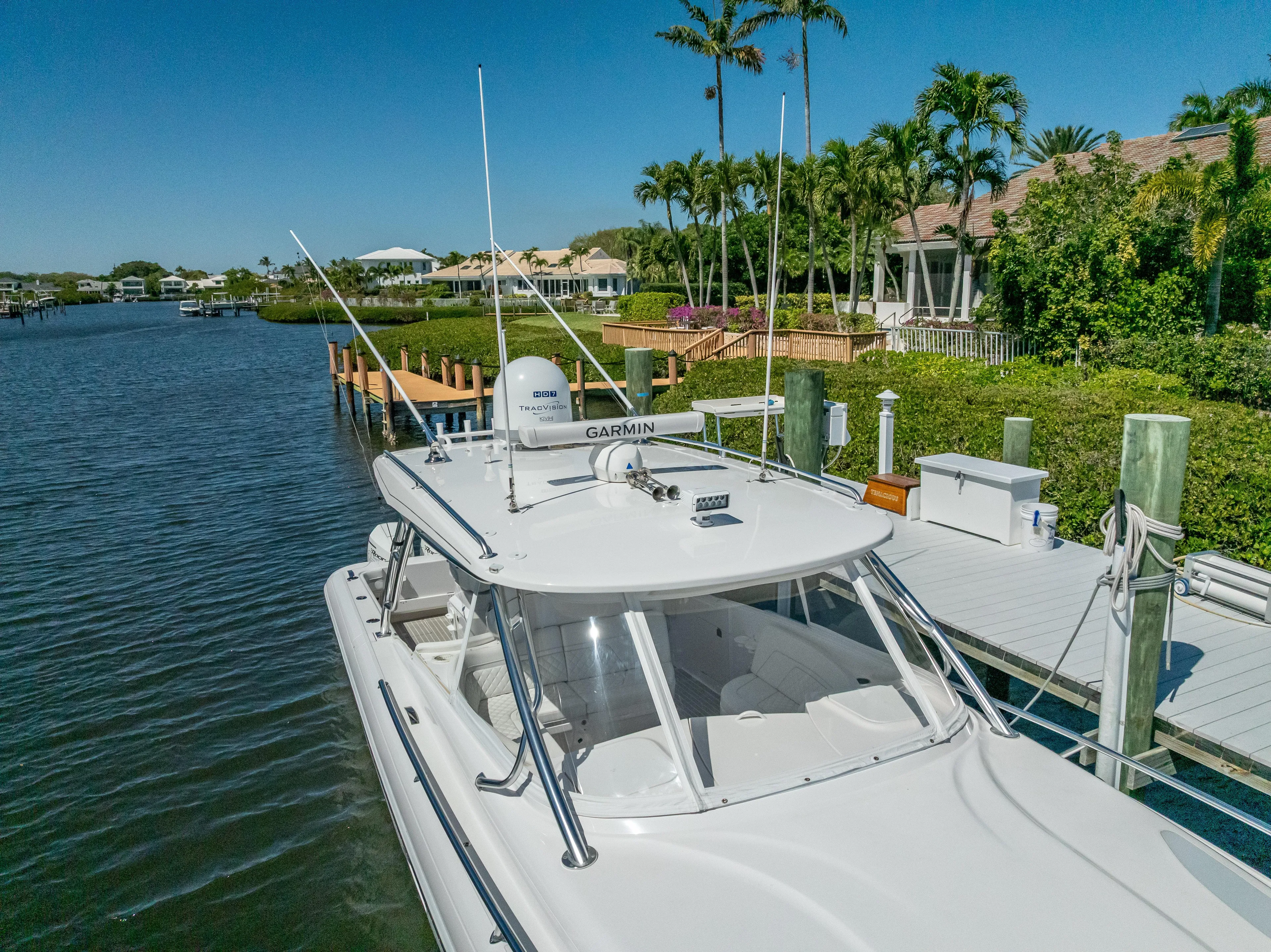  Yacht Photos Pics 2020 Intrepid 407 Cuddy docked by a scenic waterfront with lush greenery.