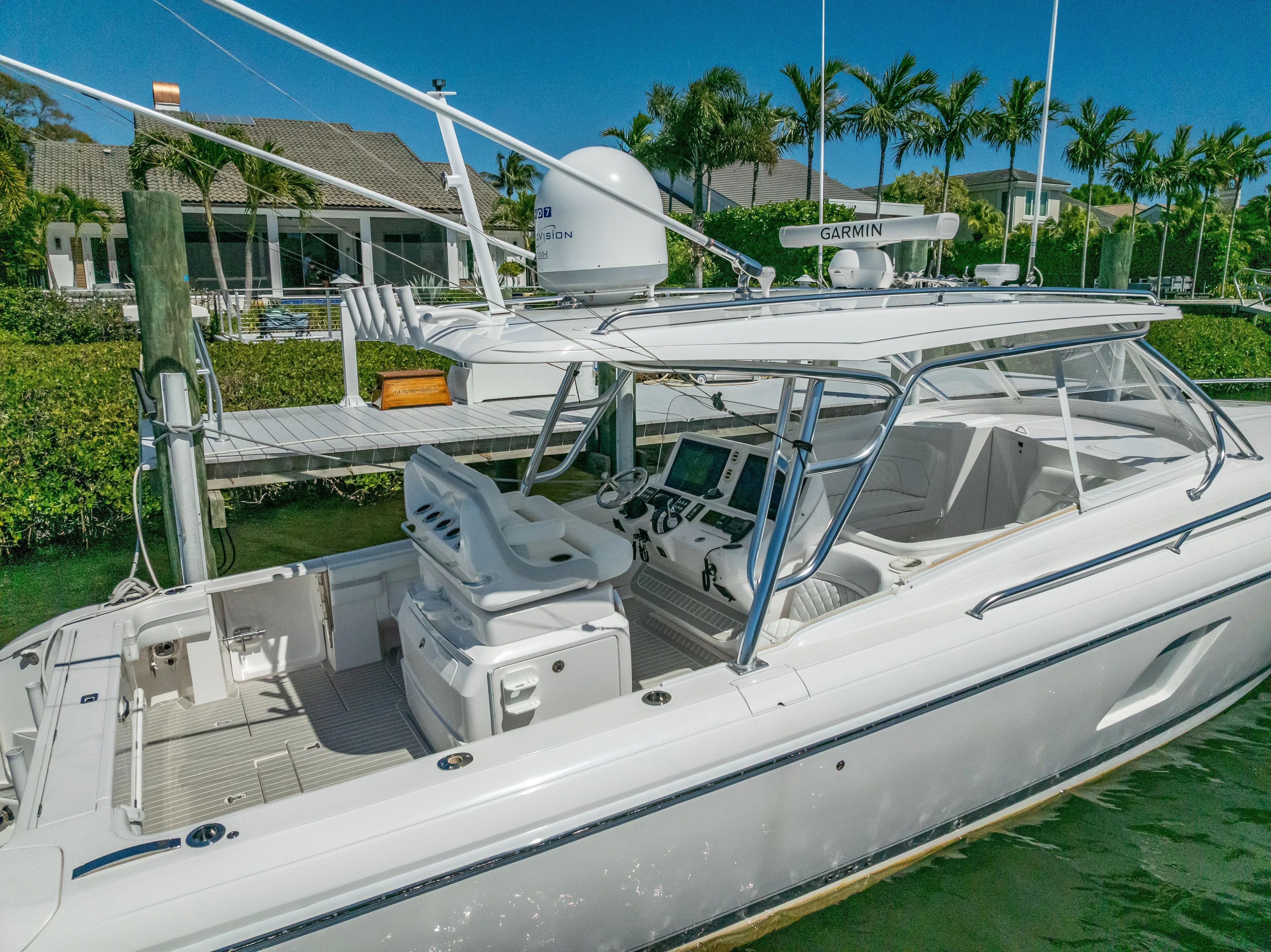  Yacht Photos Pics 2020 Intrepid 407 Cuddy boat docked near waterfront homes, featuring advanced navigation equipment.