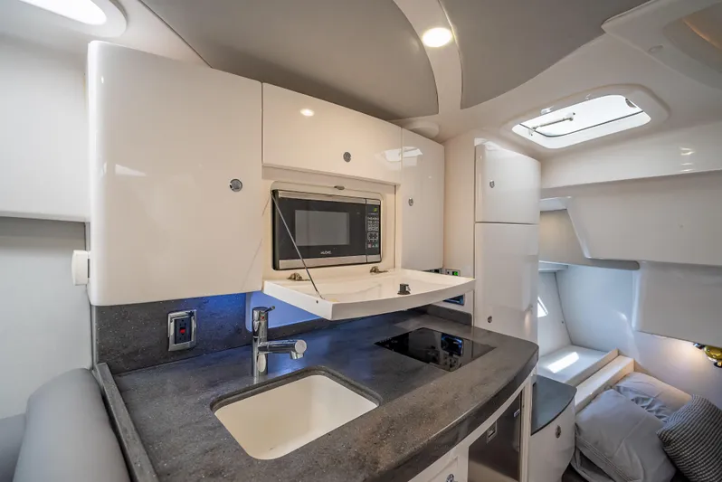  Yacht Photos Pics Interior of 2020 Intrepid 407 Cuddy, featuring a modern kitchenette and cozy sleeping area.