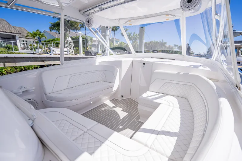  Yacht Photos Pics Luxurious interior of 2020 Intrepid 407 Cuddy boat with white seating and clear canopy.