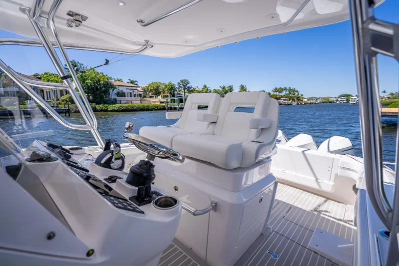  Yacht Photos Pics 2020 Intrepid 407 Cuddy boat interior with helm and seating, overlooking serene waterfront.