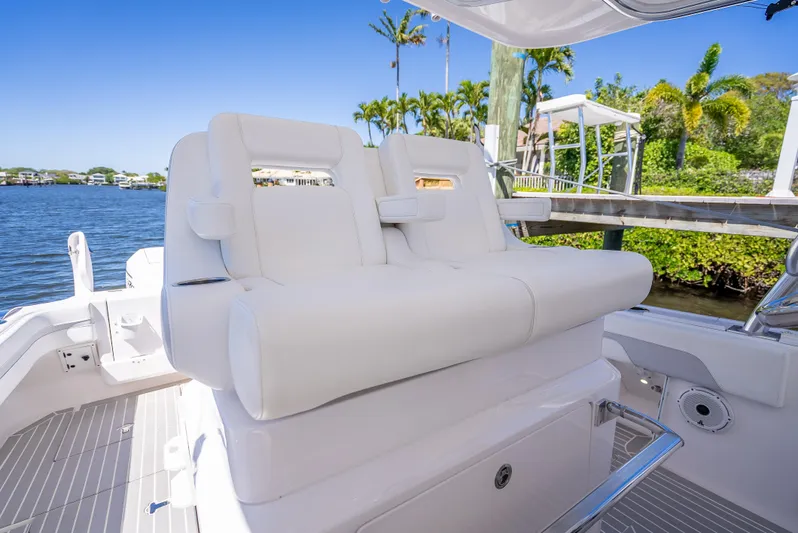  Yacht Photos Pics 2020 Intrepid 407 Cuddy boat with white seating, docked by a scenic waterfront.