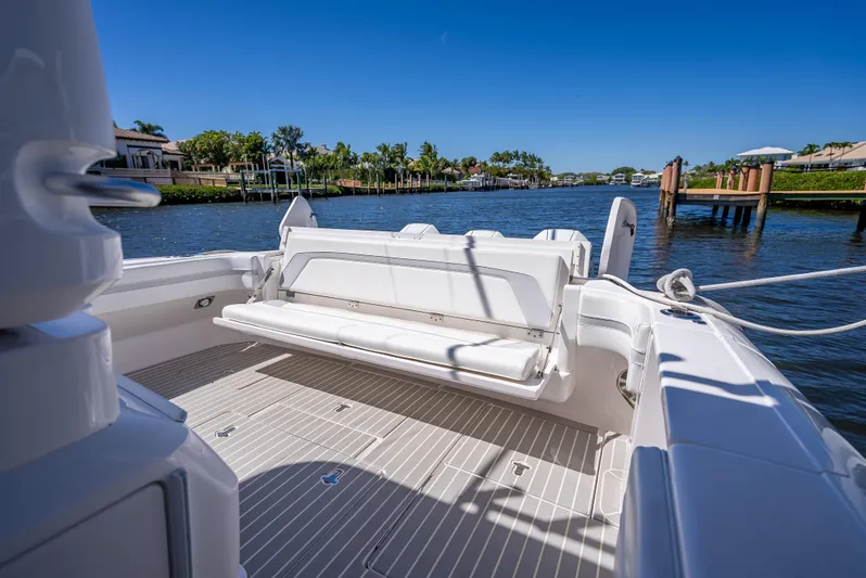  Yacht Photos Pics Intrepid 407 Cuddy 2020 boat with spacious deck and seating, docked by a scenic waterfront.