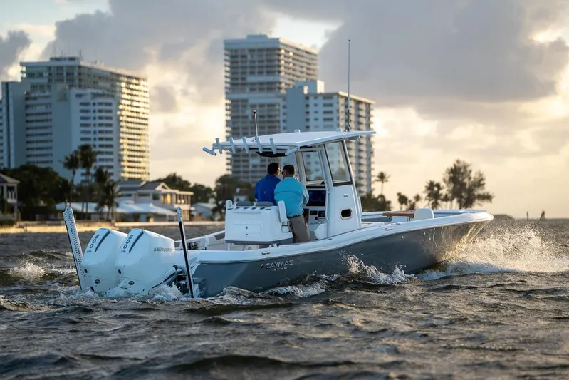  Yacht Photos Pics 2025 Caymas 291 HB boat cruising near city skyline at sunset.