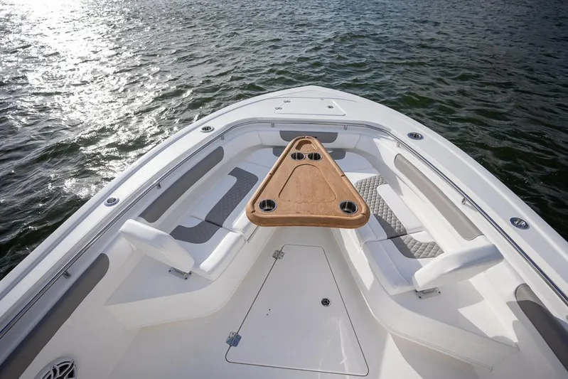  Yacht Photos Pics 2025 Caymas 291 HB boat bow with seating and triangular table on water.