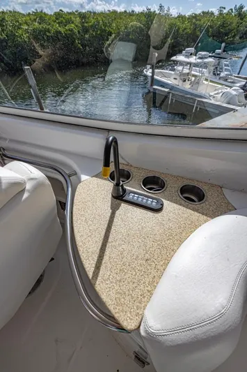 Paradise Yacht Photos Pics 2002 Carver 466 Motor Yacht interior with seating and control panel, docked near lush greenery.