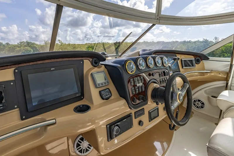 Paradise Yacht Photos Pics 2002 Carver 466 Motor Yacht helm with steering wheel, gauges, and navigation screens.