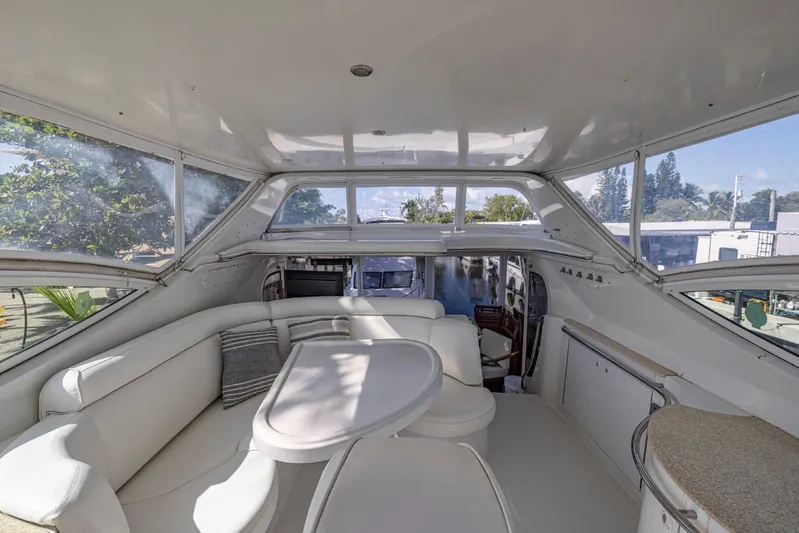 Paradise Yacht Photos Pics Spacious interior of 2002 Carver 466 Motor Yacht with white seating and panoramic windows.