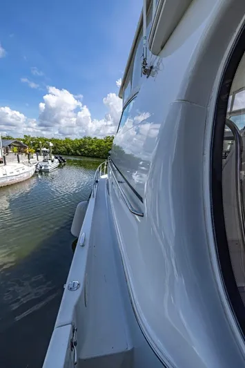 Paradise Yacht Photos Pics 2002 Carver 466 Motor Yacht docked in a serene marina under a clear blue sky.