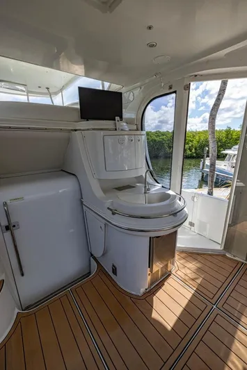 Paradise Yacht Photos Pics 2002 Carver 466 Motor Yacht interior with sink, TV, and wooden flooring.