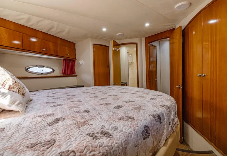 Paradise Yacht Photos Pics Luxurious bedroom interior of 2002 Carver 466 Motor Yacht with wood finishes and cozy bedding.