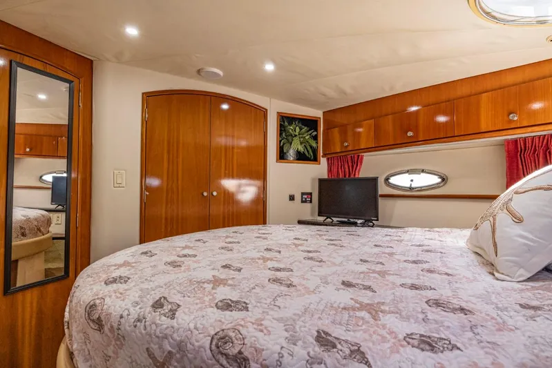 Paradise Yacht Photos Pics Luxurious 2002 Carver 466 Motor Yacht bedroom with elegant wood finishes and cozy decor.