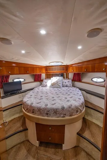 Paradise Yacht Photos Pics Luxurious 2002 Carver 466 Motor Yacht bedroom with circular bed and elegant wood finish.