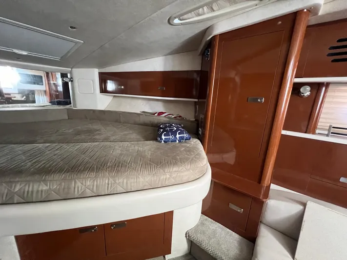 Vitamin Sea Yacht Photos Pics Interior cabin of 2010 Sea Ray 330 Sundancer with bed and wooden cabinetry.