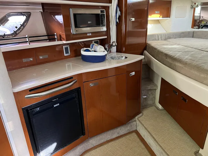 Vitamin Sea Yacht Photos Pics Interior of 2010 Sea Ray 330 Sundancer yacht with kitchenette and bed.