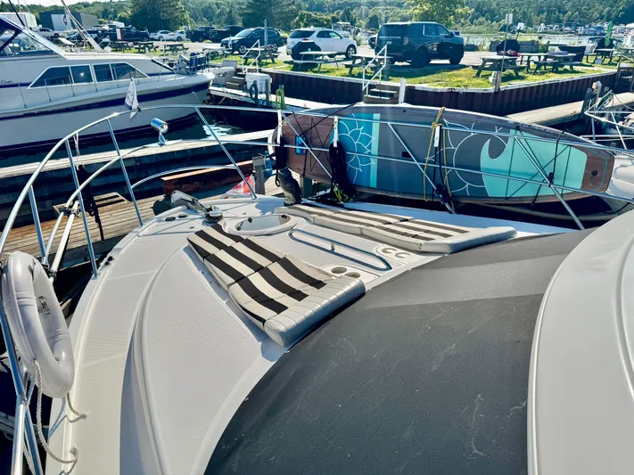  Yacht Photos Pics 2005 Meridian 459 CMY yacht with striped sun pads and paddleboards at a marina.