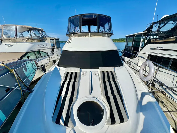  Yacht Photos Pics 2005 Meridian 459 CMY yacht docked, featuring sleek design and striped seating on deck.