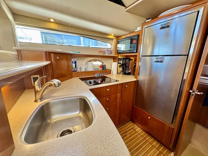  Yacht Photos Pics Luxurious 2005 Meridian 459 CMY yacht kitchen with modern appliances and sleek wood cabinetry.