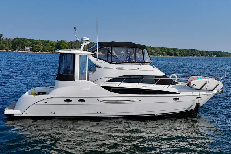  Yacht Photos Pics 2005 Meridian 459 CMY yacht cruising on a serene lake with lush green shoreline.