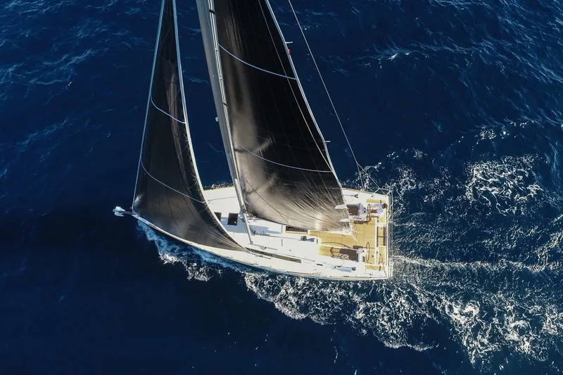 Wanderlust Yacht Photos Pics Aerial view of 2019 Beneteau Oceanis 38.1 sailing on open blue sea.
