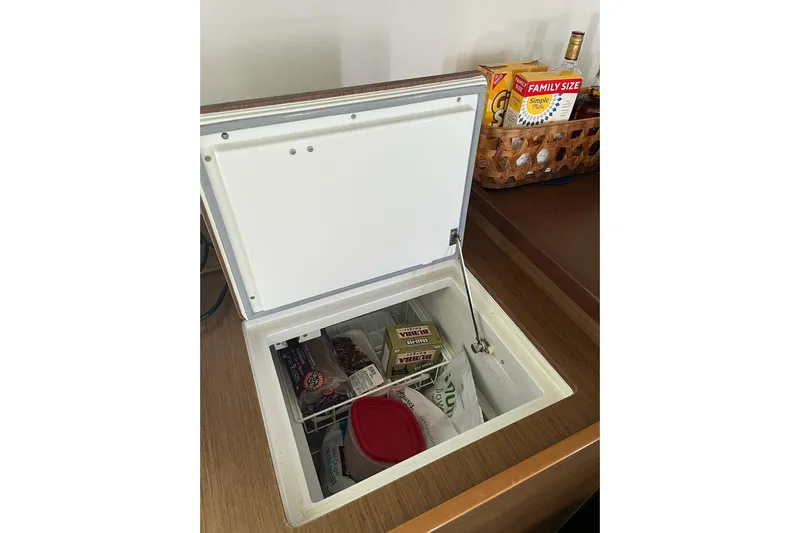 Always Sunday Yacht Photos Pics Open freezer on Lagoon 42 yacht, stocked with various food items and snacks.