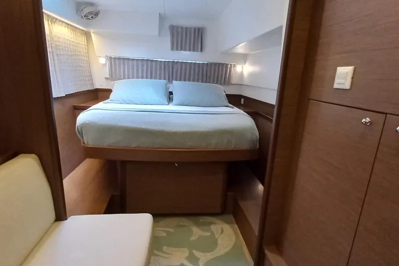 Always Sunday Yacht Photos Pics Interior of 2020 Lagoon 42 yacht cabin with bed and wooden furnishings.