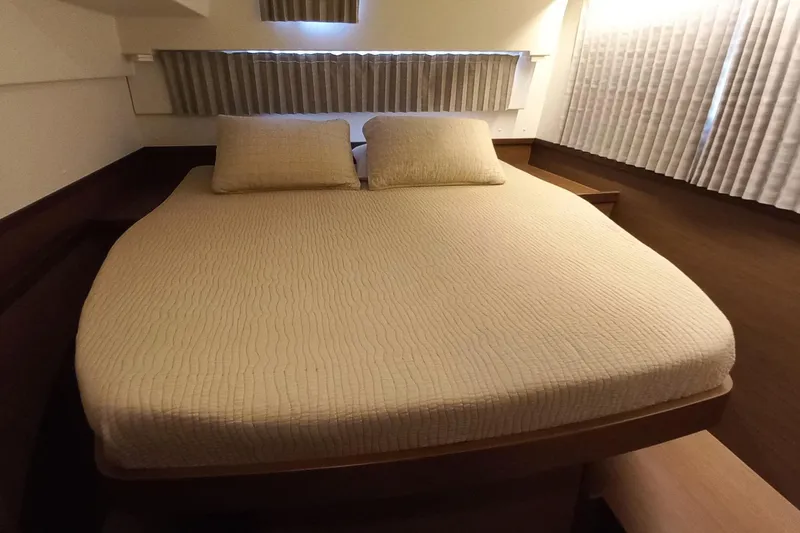 Always Sunday Yacht Photos Pics Cozy bedroom interior of 2020 Lagoon 42 catamaran with beige bedding and curtains.