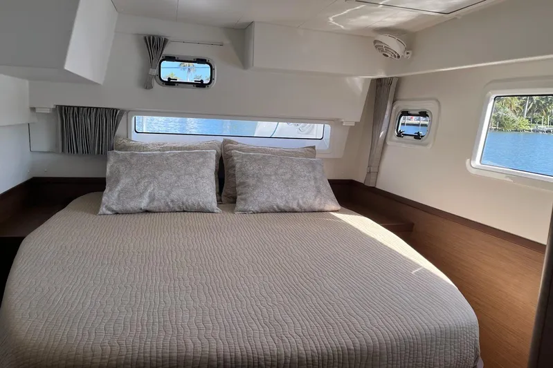 Always Sunday Yacht Photos Pics Luxurious interior cabin of 2020 Lagoon 42 catamaran with cozy bedding and scenic windows.