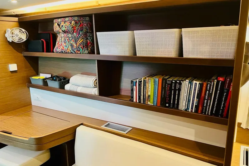 Always Sunday Yacht Photos Pics Interior of 2020 Lagoon 42 yacht with bookshelves, storage baskets, and a colorful bag.