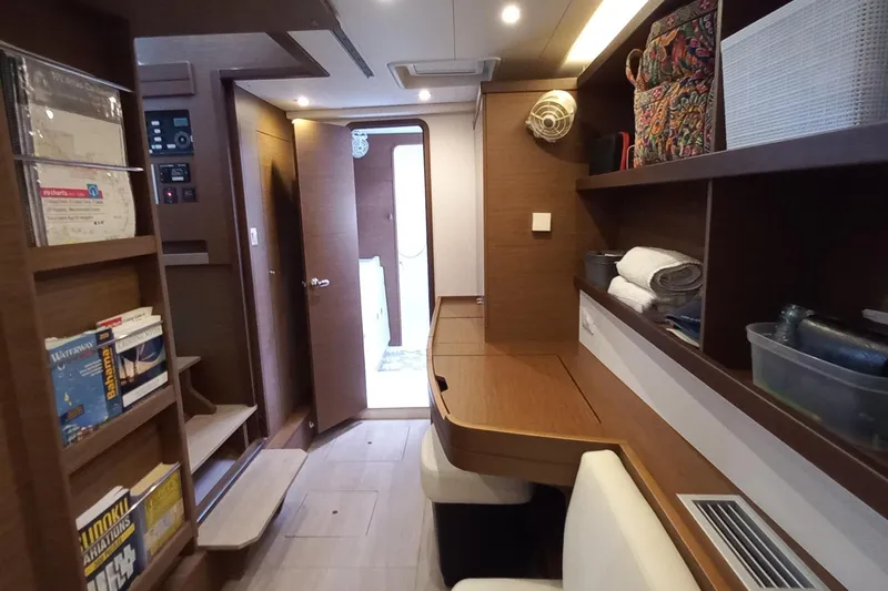 Always Sunday Yacht Photos Pics Interior of 2020 Lagoon 42 catamaran with wooden shelves, books, and cozy seating area.