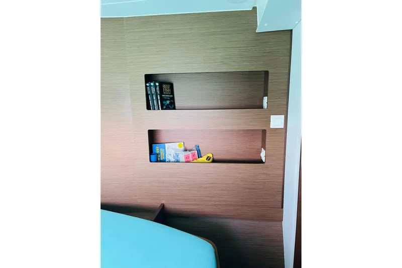 Always Sunday Yacht Photos Pics Interior of 2020 Lagoon 42 yacht with built-in wooden shelves and books.