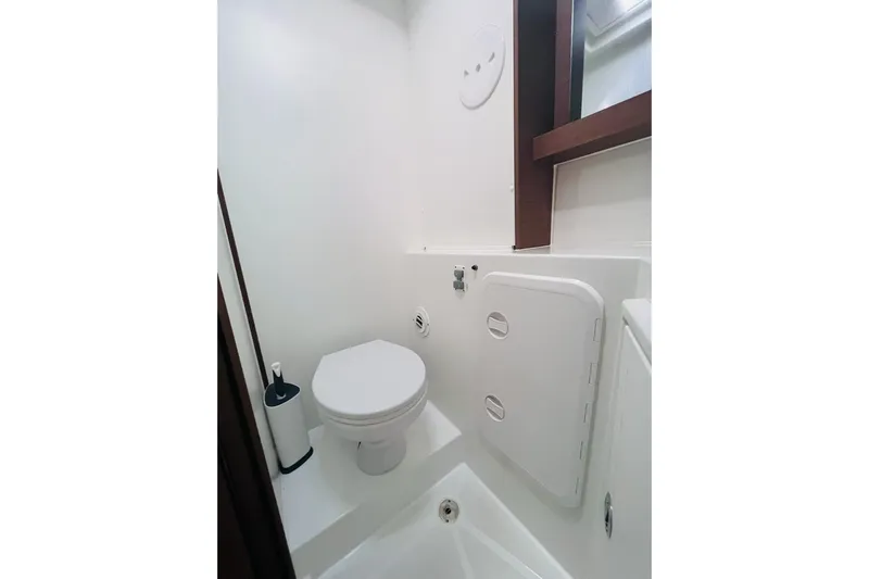 Always Sunday Yacht Photos Pics Compact bathroom in 2020 Lagoon 42 yacht, featuring a modern toilet and storage compartment.