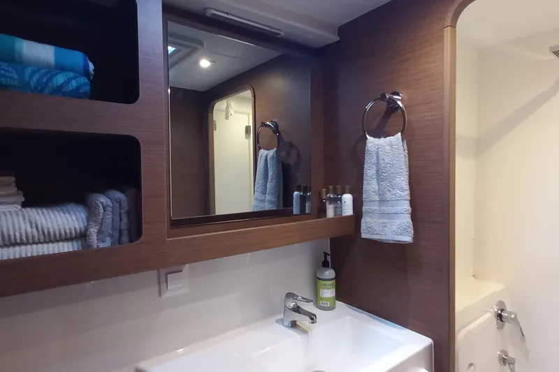 Always Sunday Yacht Photos Pics Modern bathroom interior on 2020 Lagoon 42 yacht with wooden accents and neatly arranged towels.