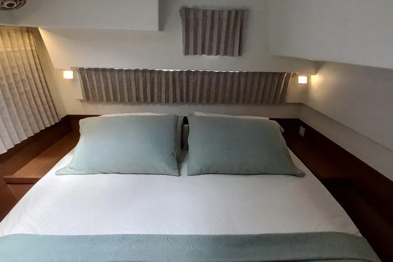 Always Sunday Yacht Photos Pics Luxurious bedroom interior of 2020 Lagoon 42 catamaran with elegant bedding and soft lighting.