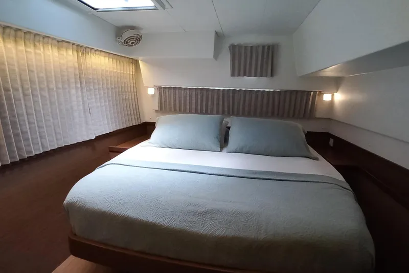 Always Sunday Yacht Photos Pics Cozy bedroom interior of 2020 Lagoon 42 yacht with elegant bedding and soft lighting.