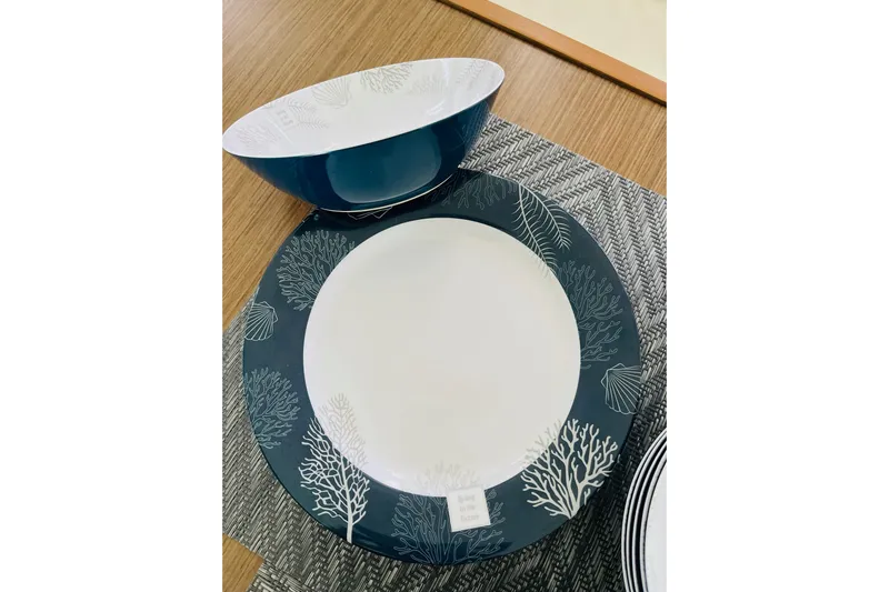 Always Sunday Yacht Photos Pics Elegant nautical-themed dinnerware set on a wooden table, featuring coral designs.