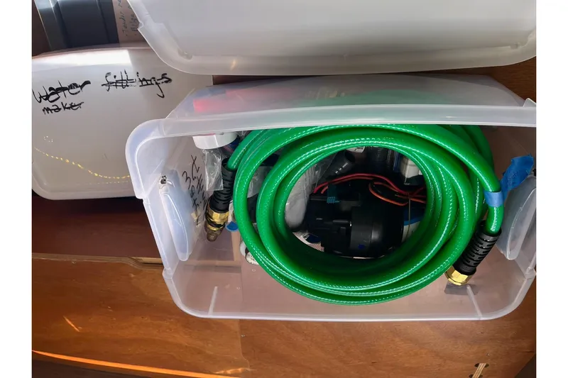 Always Sunday Yacht Photos Pics Plastic container with green hose and fittings, labeled "water fittings," on Lagoon 42, 2020 model.