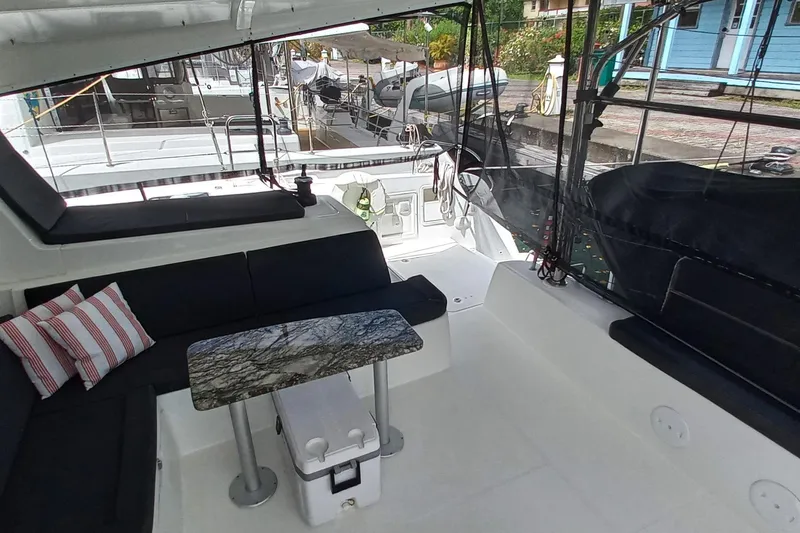 Always Sunday Yacht Photos Pics Spacious cockpit of 2020 Lagoon 42 catamaran with seating and table, docked at marina.
