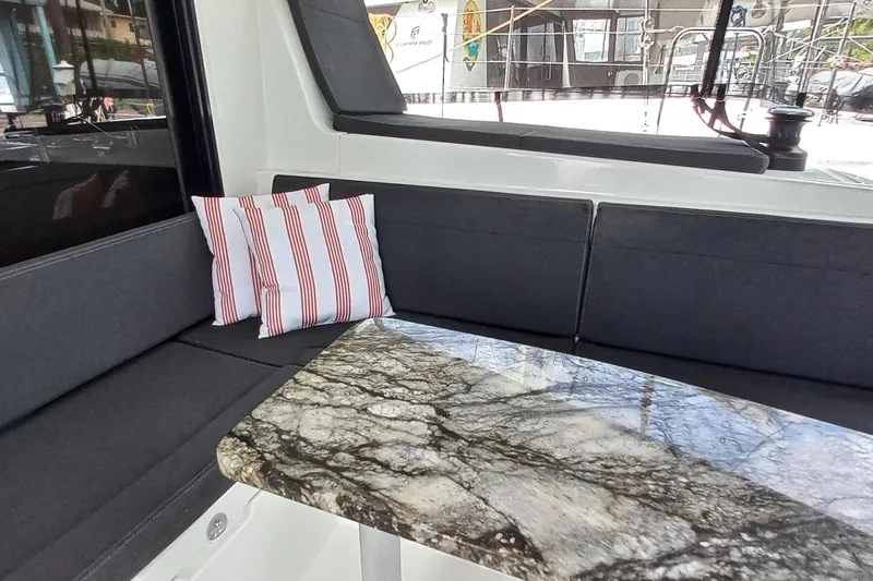 Always Sunday Yacht Photos Pics Interior of 2020 Lagoon 42 yacht with marble table and striped cushions.