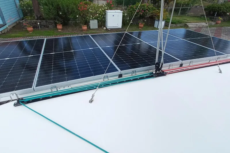 Always Sunday Yacht Photos Pics Solar panels on a 2020 Lagoon 42 catamaran, surrounded by lush greenery.